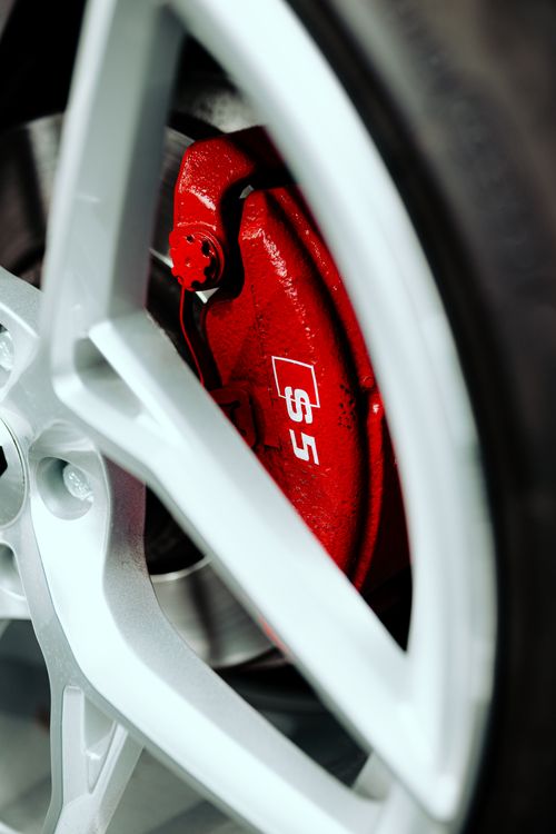Free Macro shot of a red brake caliper and alloy wheel showcasing automotive engineering. Stock Photo