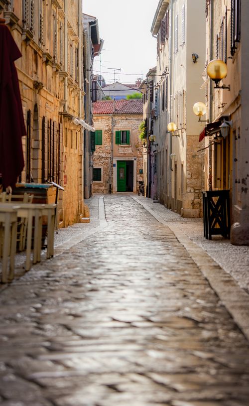 Free Serene cobblestone street between traditional European buildings, perfect for travel inspiration. Stock Photo