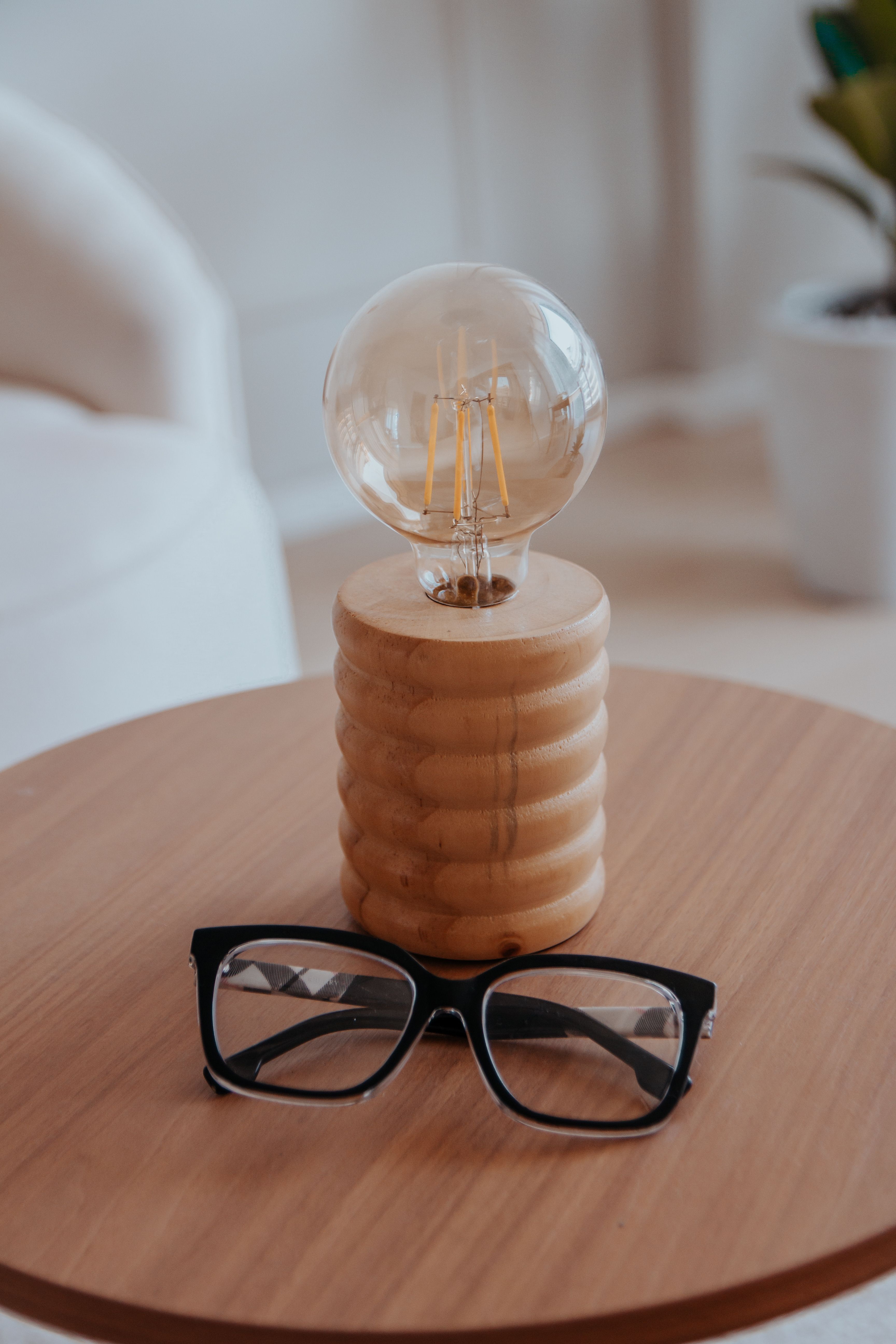 A wooden table with glasses and a light bulb on it · Free Stock Photo