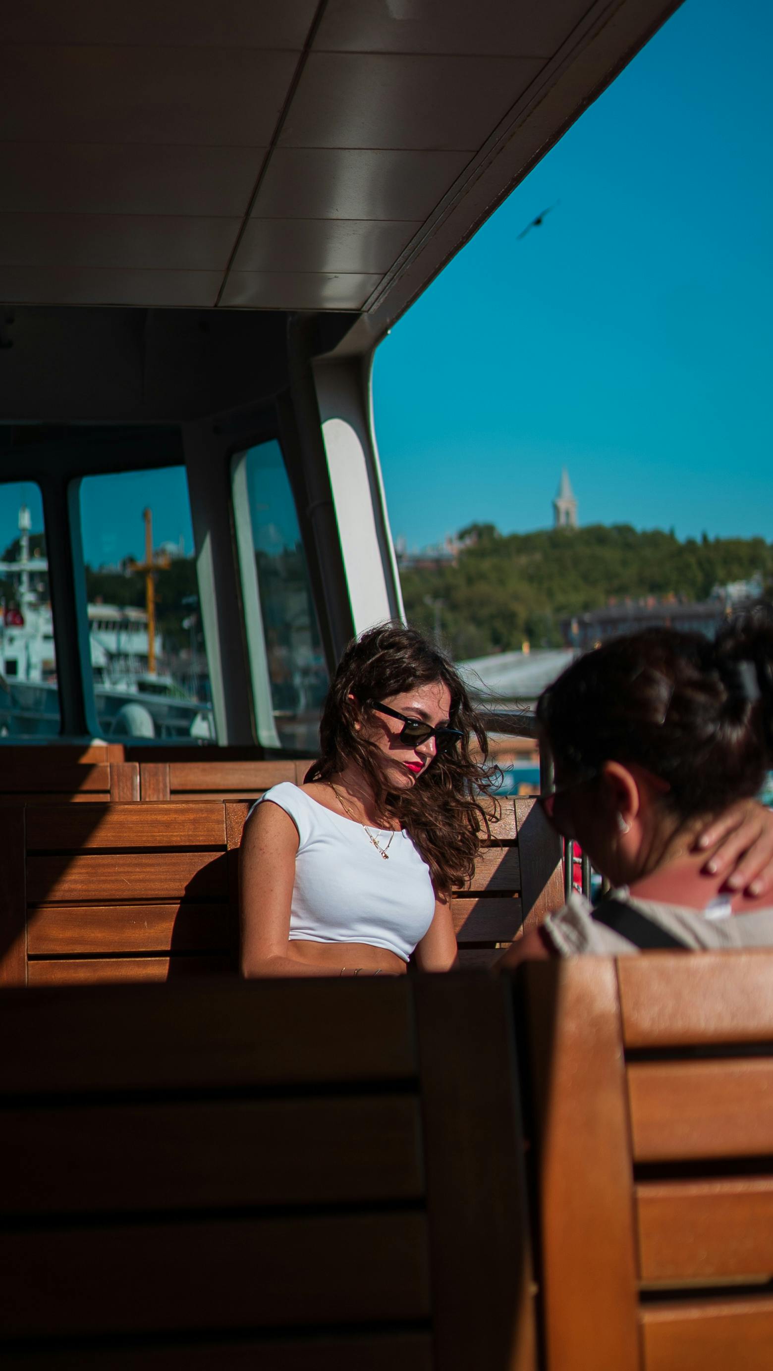 a woman sitting on a wooden bench looking at her phone