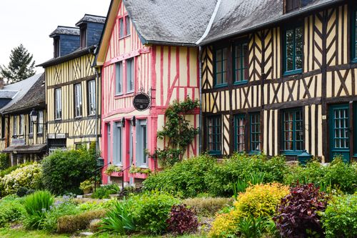 Free Colorful half-timbered houses in a traditional Normandy village with lush gardens. Stock Photo