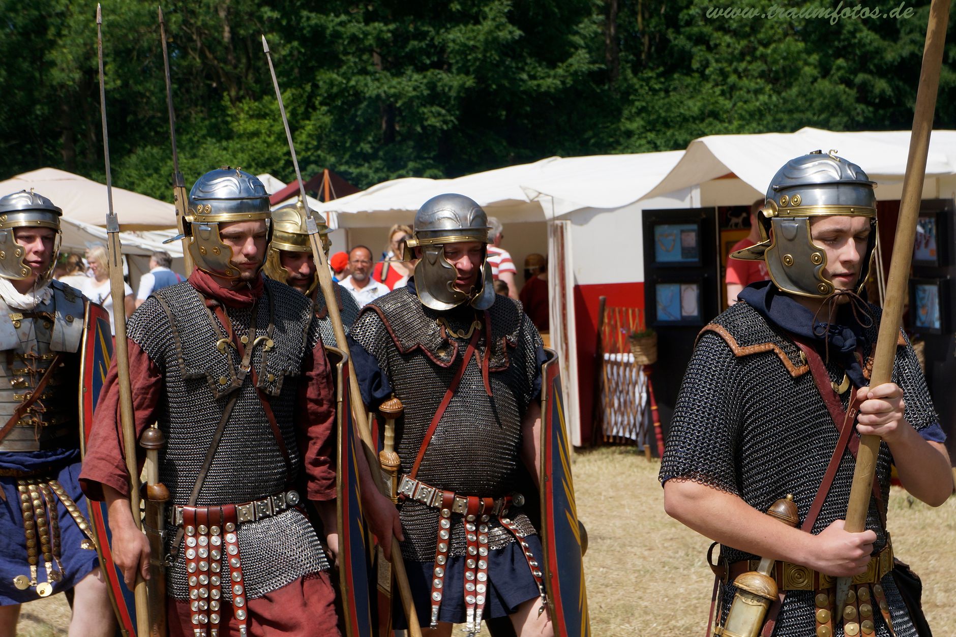 Military historical reconstruction male group in metal helmets and weapons in sunny warm day