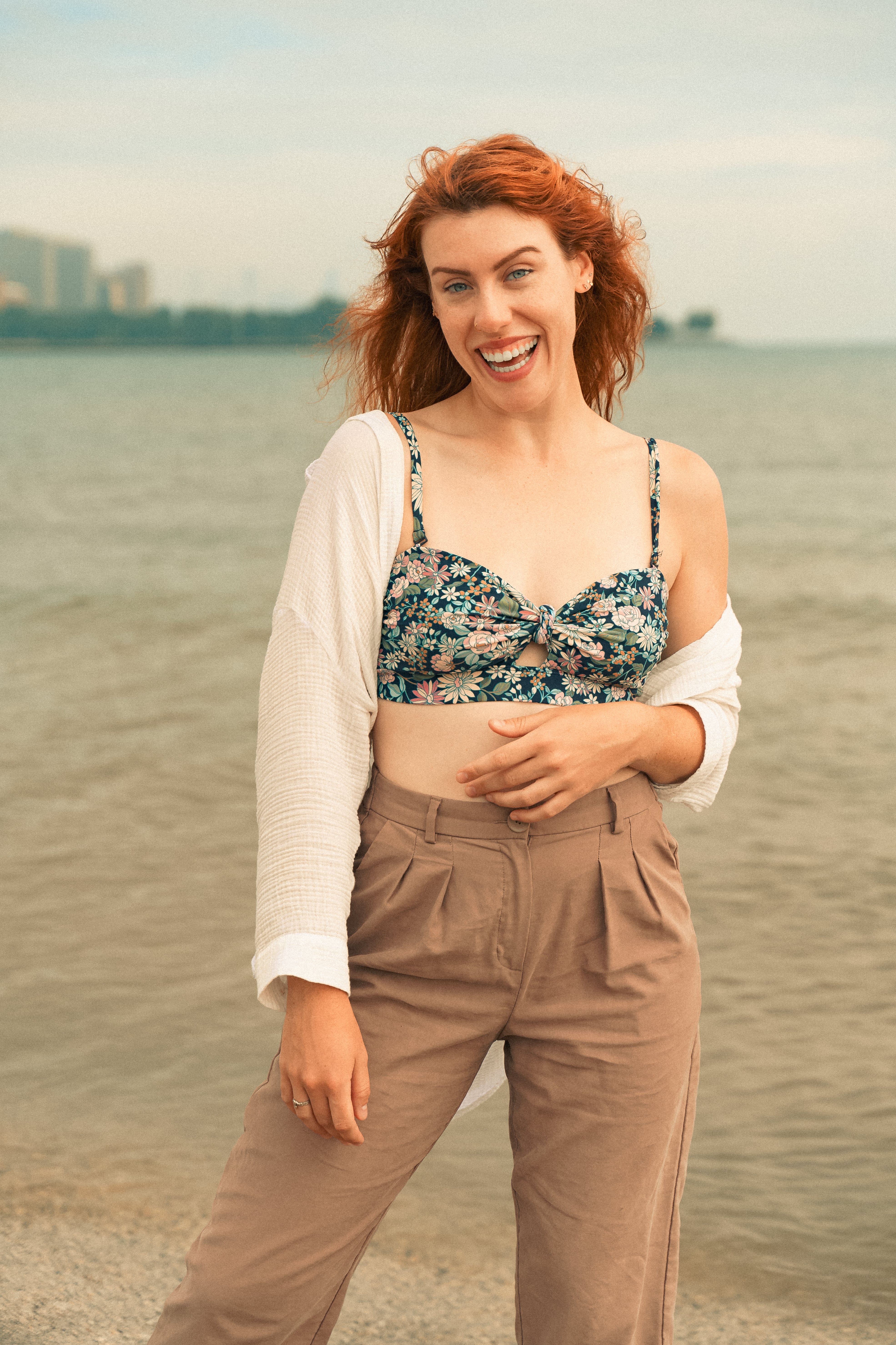 A woman smiles at the lakeside in Chicago, embodying summer leisure and fun.
