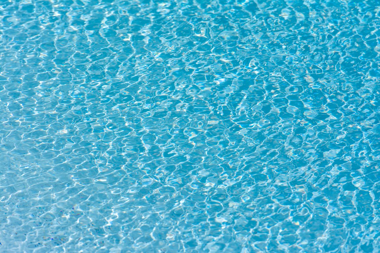 texture and pattern of rippling turquoise water in a swimming pool wit
