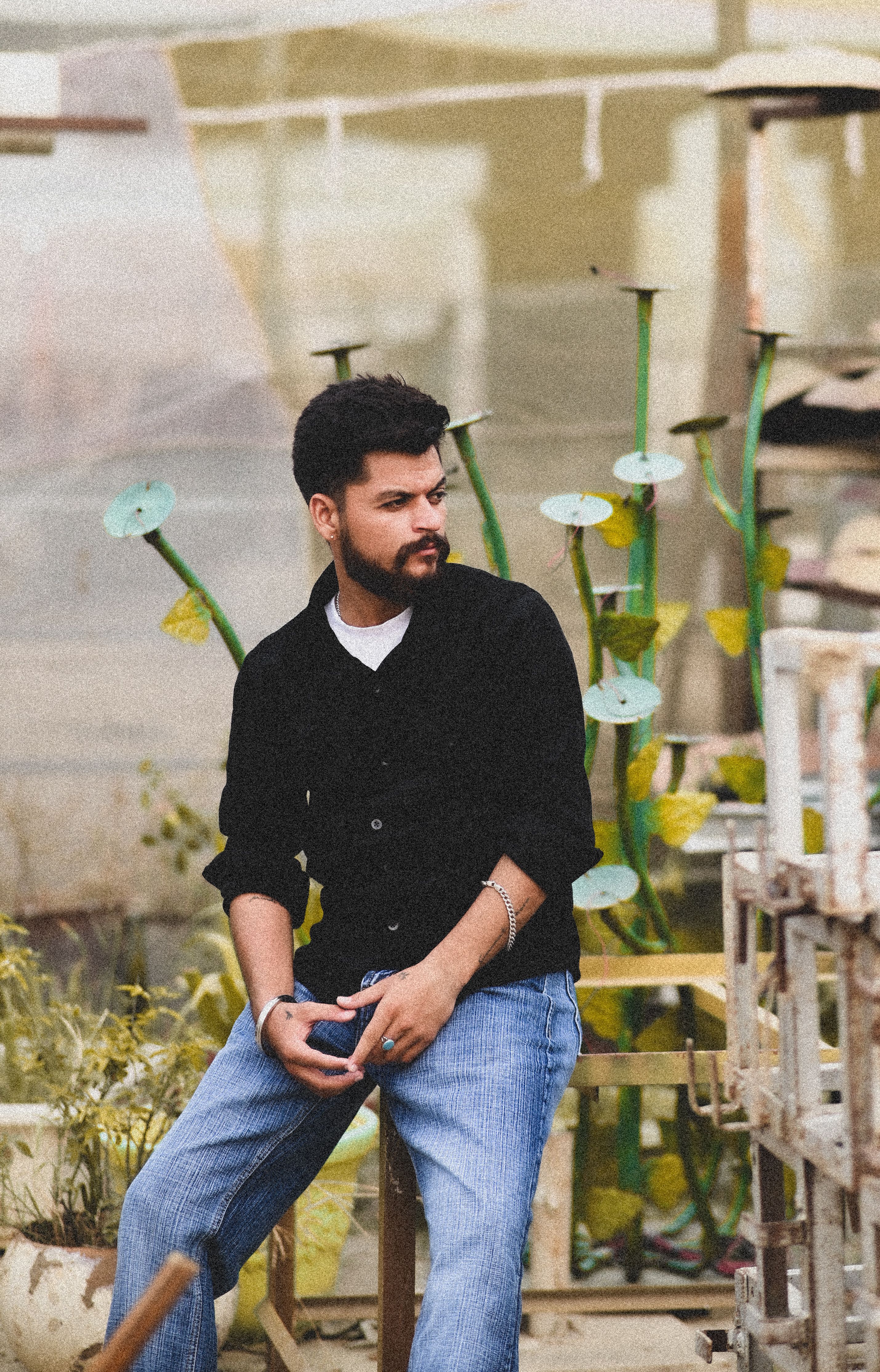 Young man in casual attire sitting outdoors, showcasing modern lifestyle in Chandigarh, India.