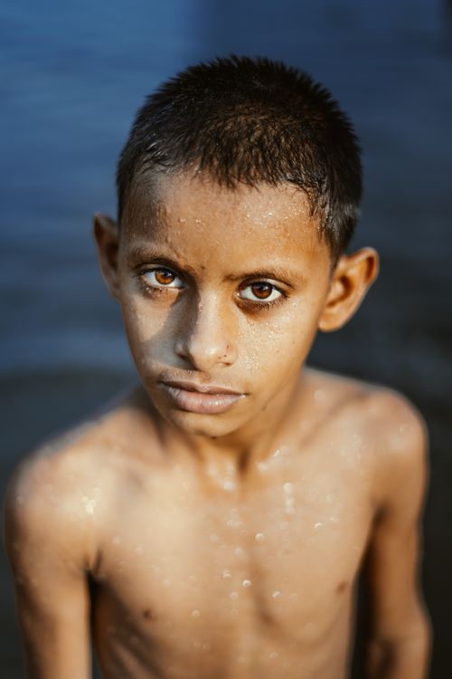 Free Portrait of a child with water droplets, capturing a serious expression outdoors. Stock Photo