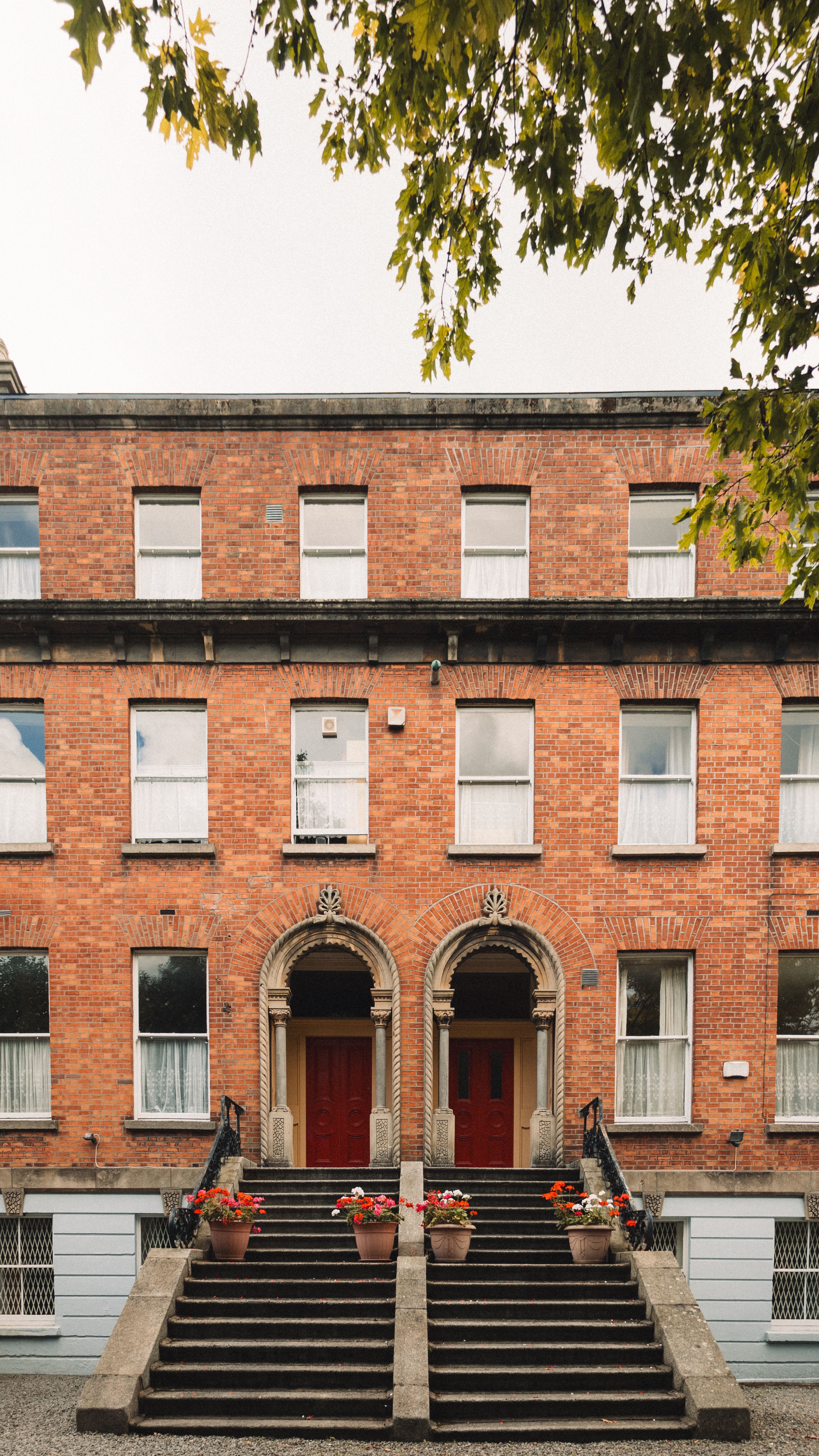 A red brick building with stairs and a red door · Free Stock Photo