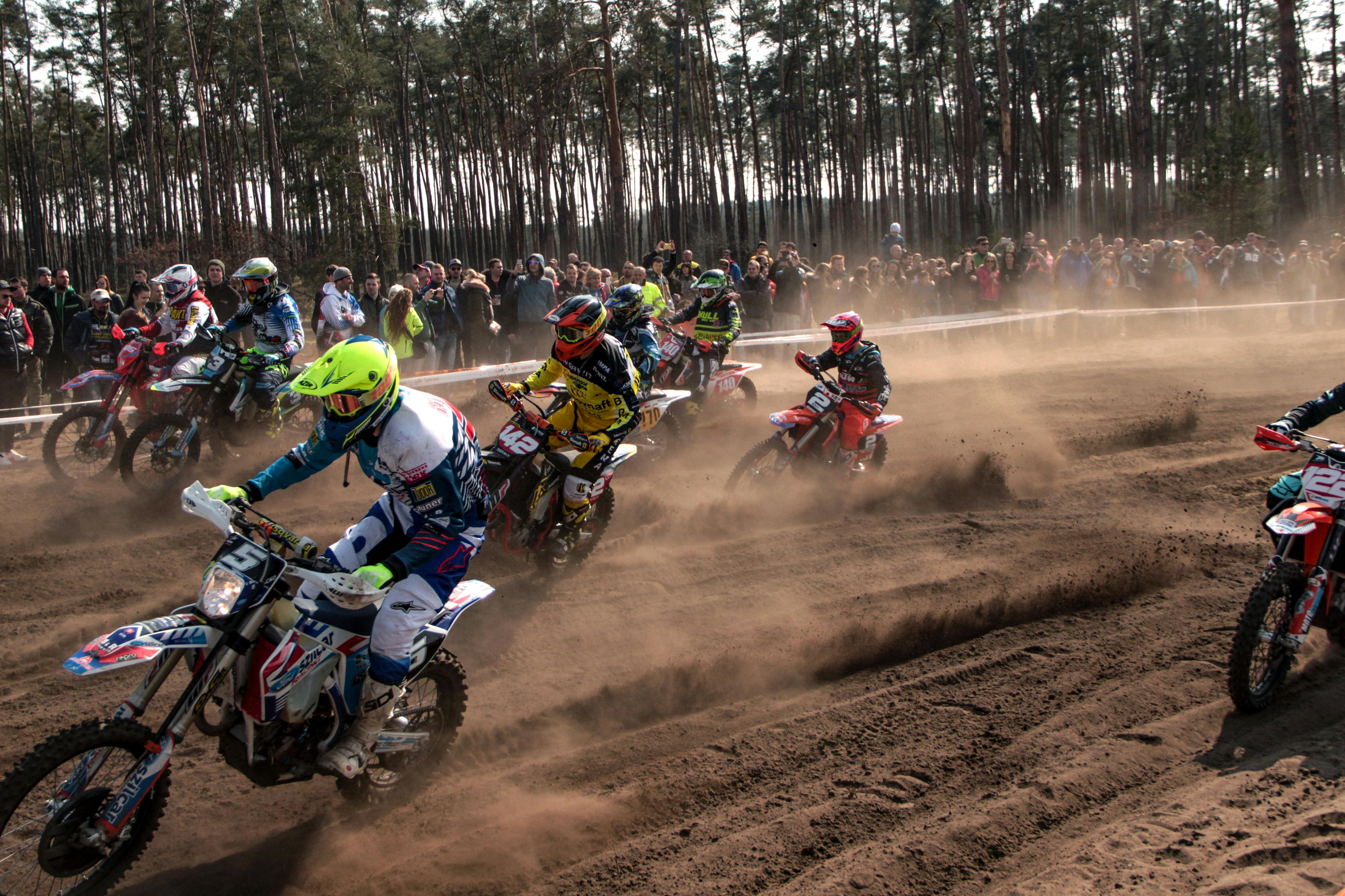 Several motorcyles racing on a dirt track, By Michal Hudcovic