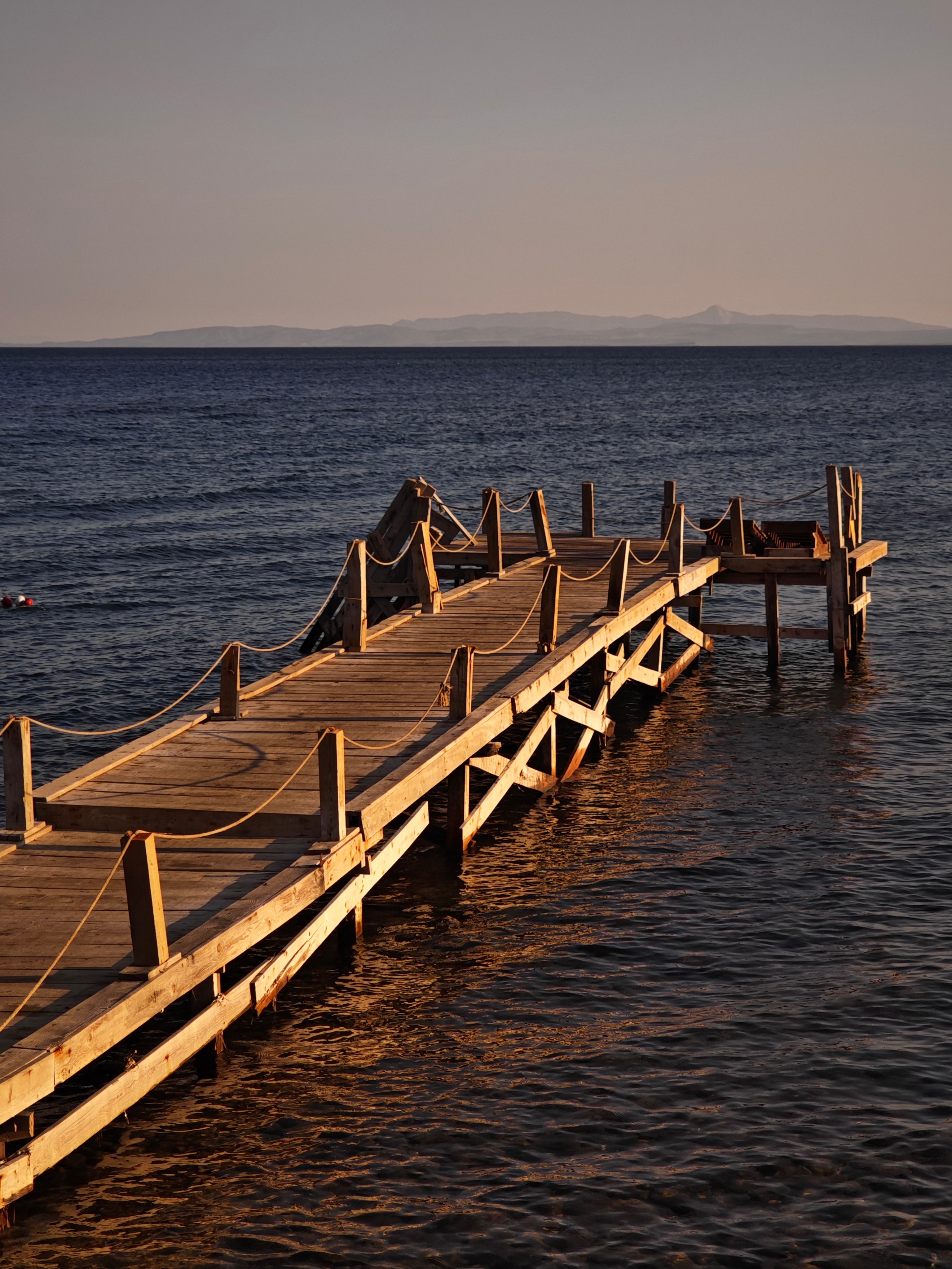 A wooden pier in the ocean with a boat on it · Free Stock Photo