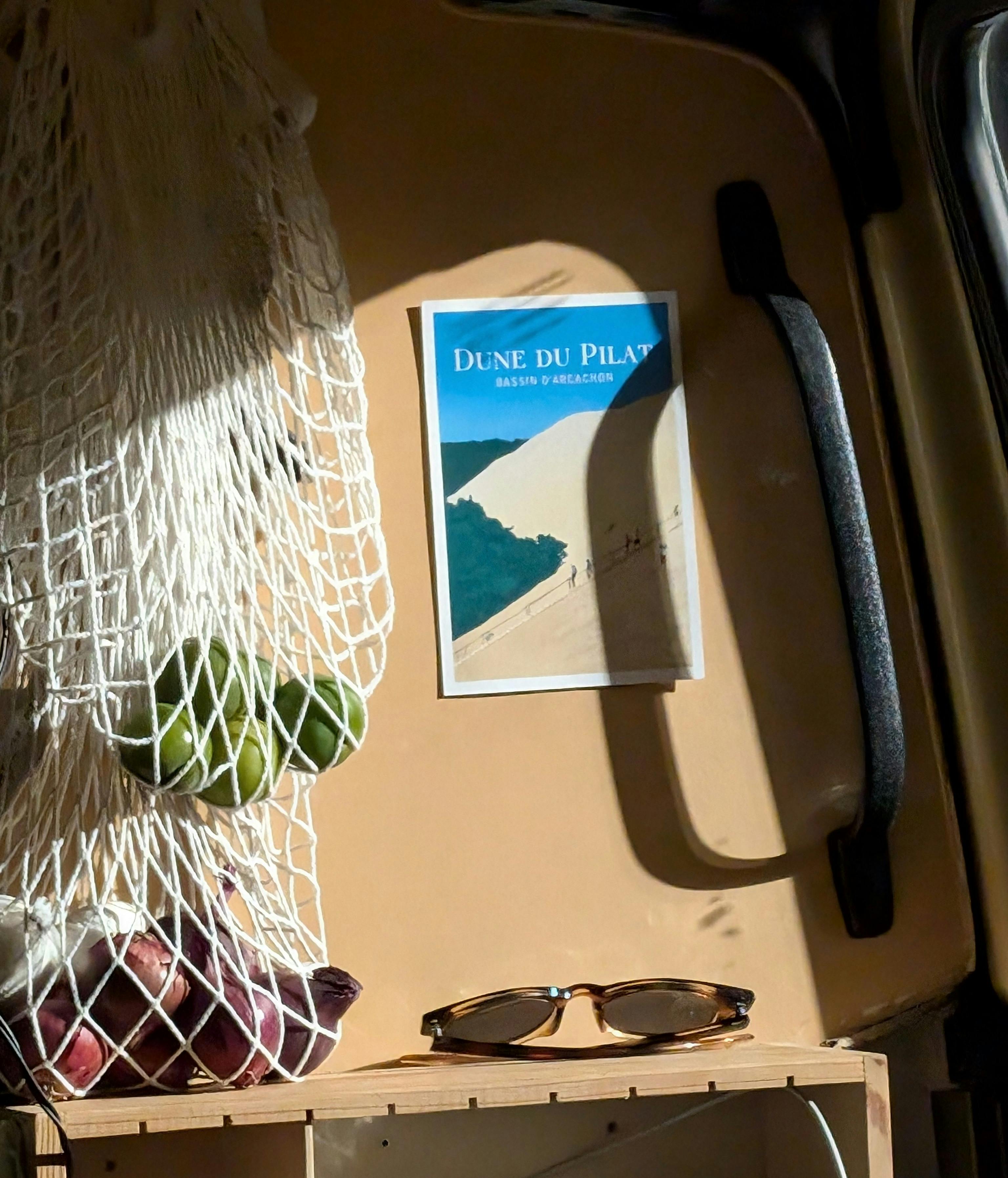 бесплатная Уютный интерьер автодома, где свежие продукты упакованы в сетчатый мешок, а также есть открытка с изображением Дюны Пила. Стоковое фото