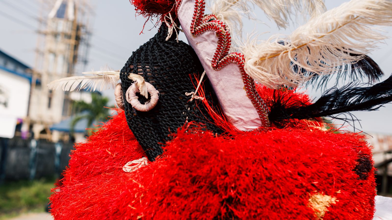 A close up of a red hat with feathers, Nigeria