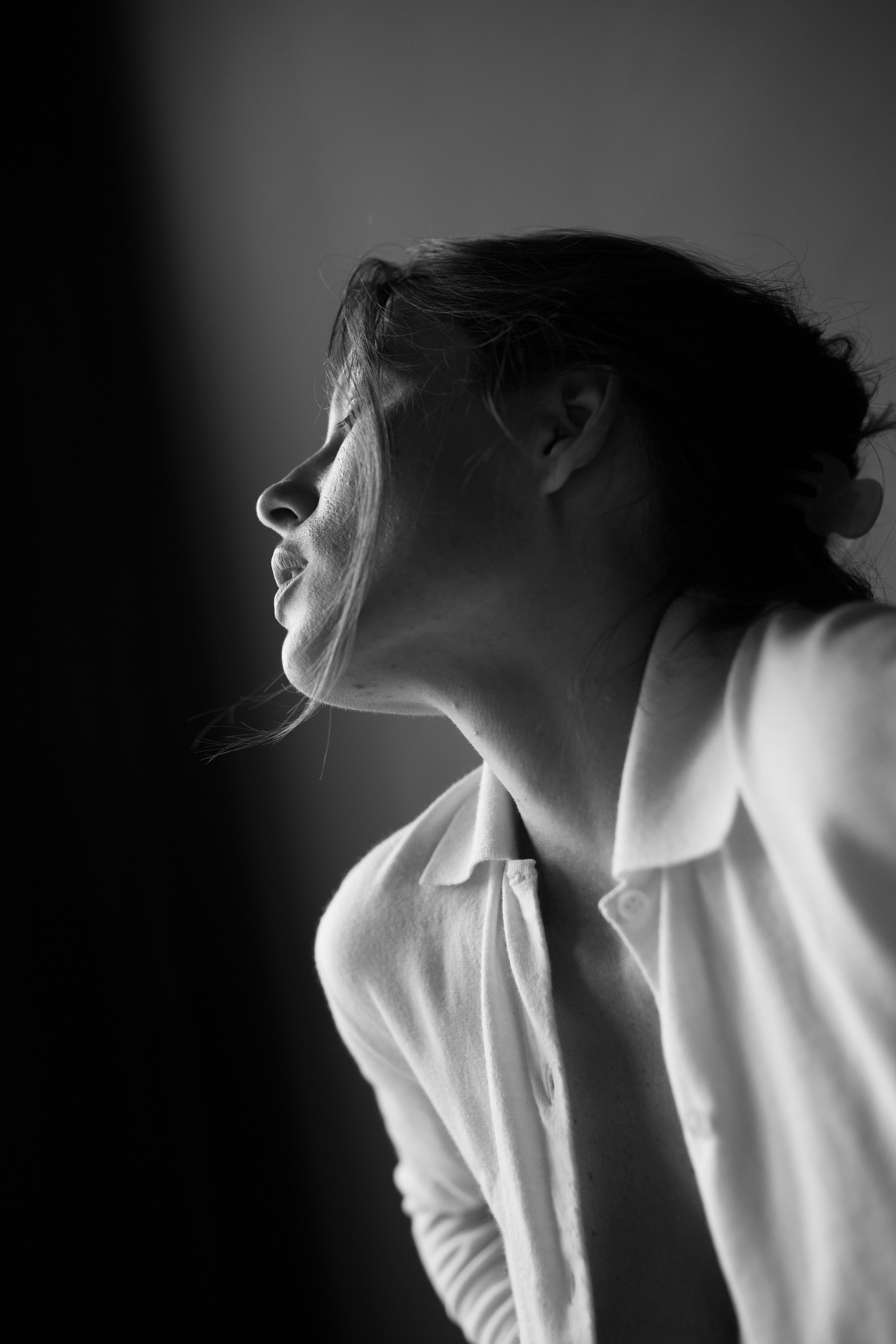 Artistic black and white portrait of a young woman in profile, highlighting elegance and emotion.
