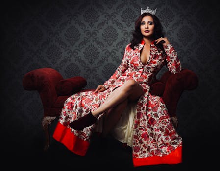 Glamorous studio portrait of an elegant woman in a floral dress with a crown, exuding fashion and sophistication.