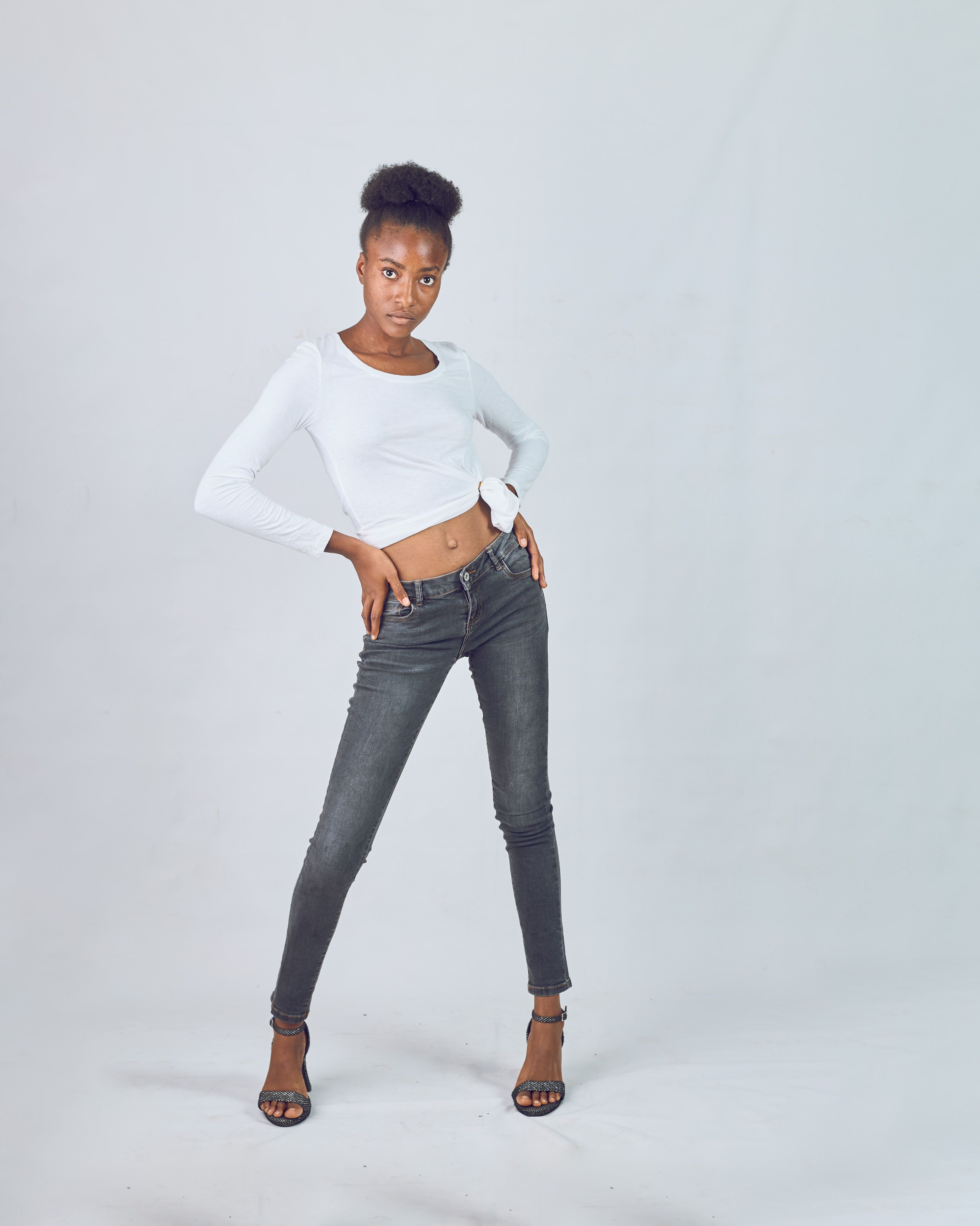 Fashion model posing confidently in a minimalist studio setting, showcasing contemporary style.