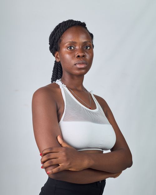 Free Portrait of a confident African woman in a stylish white top in a studio setting. Stock Photo