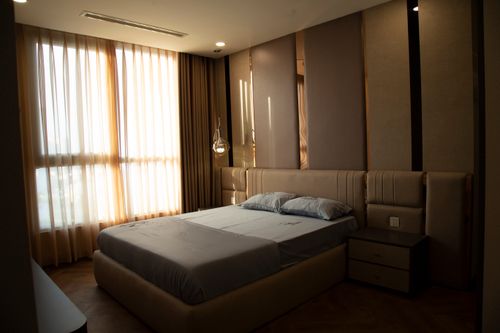 Free Luxurious modern bedroom with a stylish design and abundant natural light streaming through large windows. Stock Photo