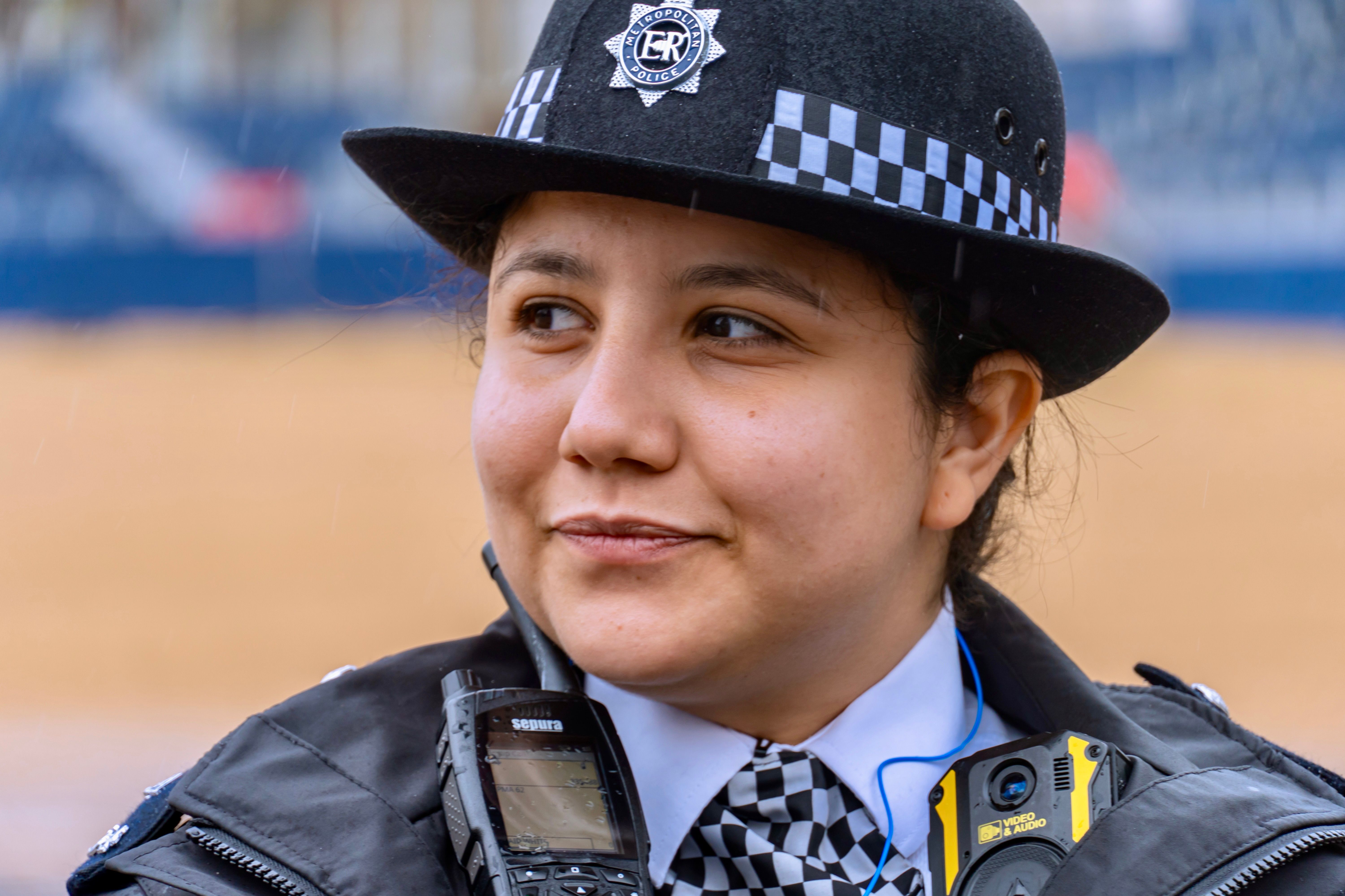 A female police officer in uniform smiles during her duty in England, United Kingdom.