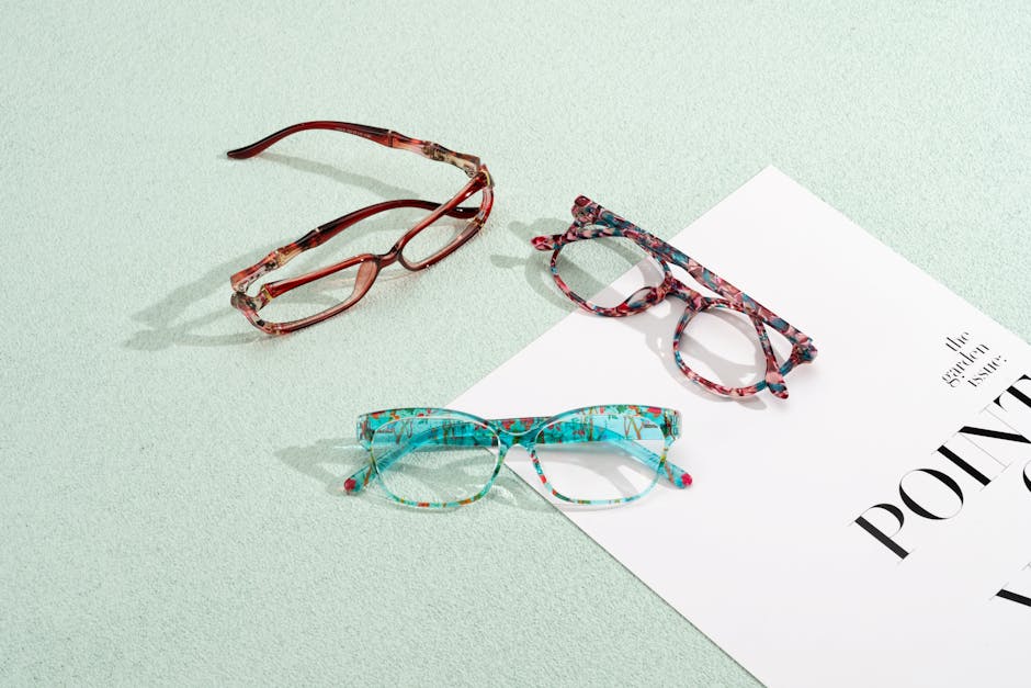 Three vibrant eyeglasses on a pastel surface with a magazine layout, perfect for fashion and design themes.