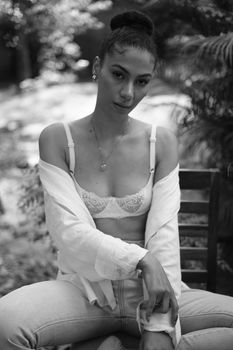 Black and white portrait of a woman in casual fashion outdoors.
