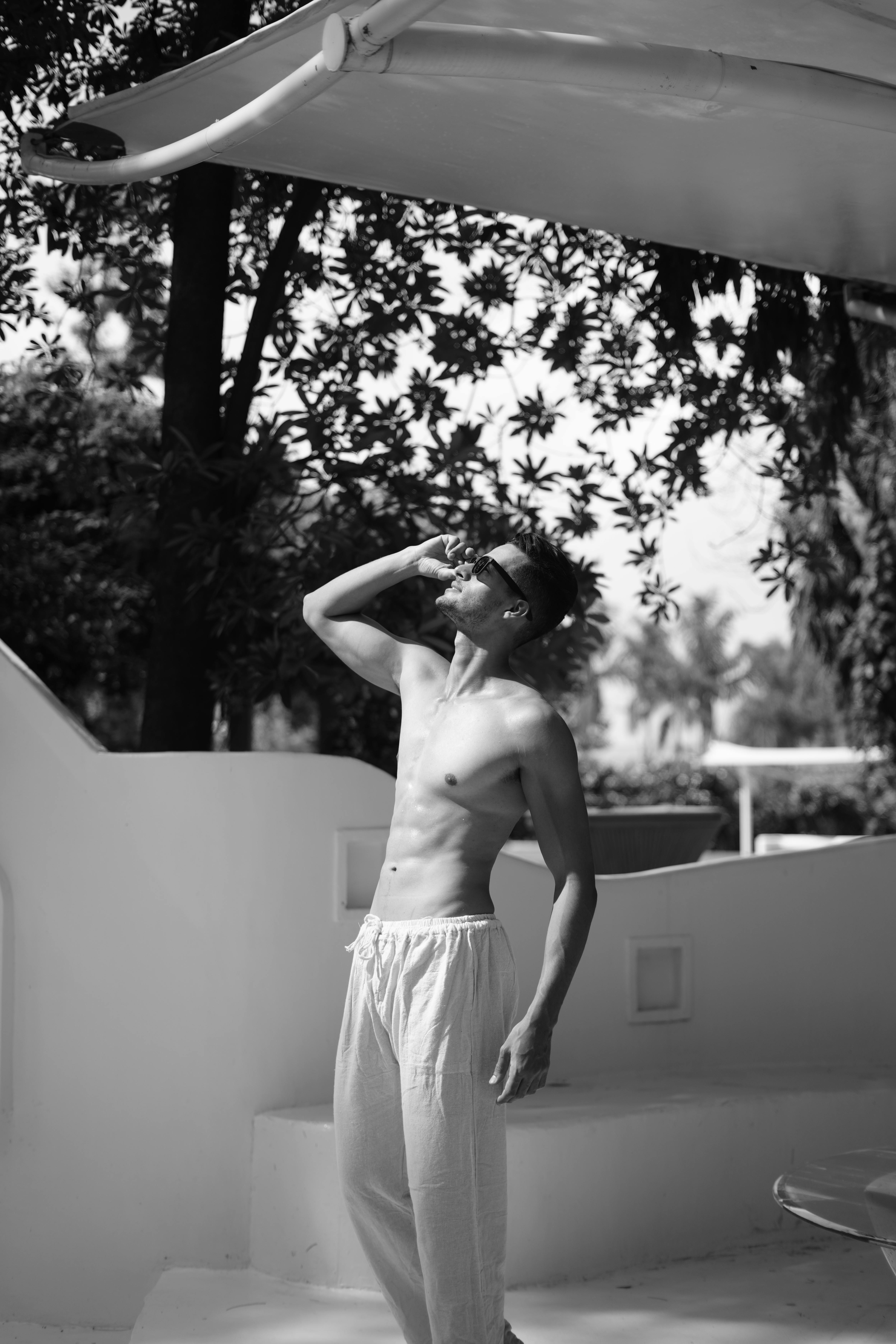 Free A man enjoys sunny weather under a shade, exuding a carefree summer vibe. Stock Photo