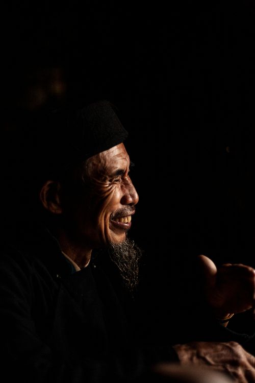 Free Side view portrait of a smiling man with facial hair and a dark background. Stock Photo