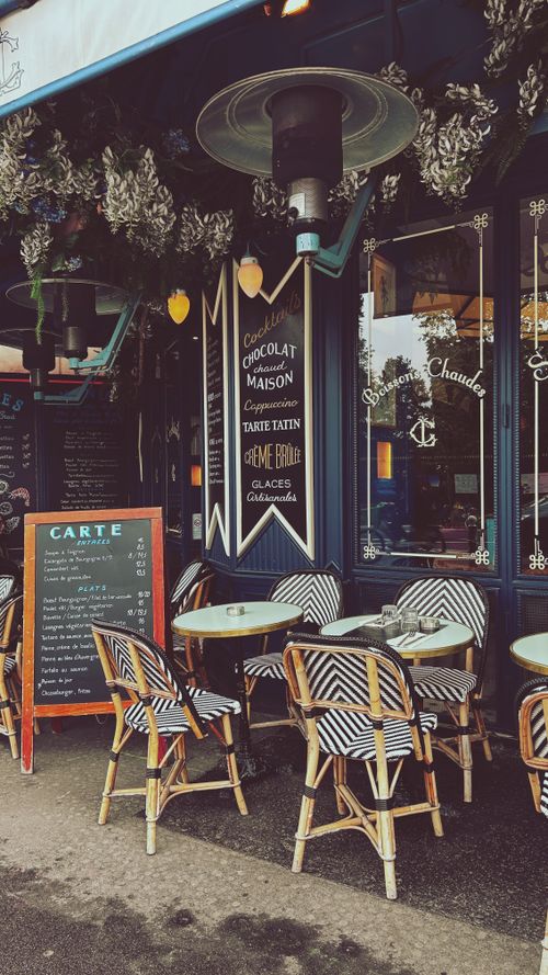 Free Elegant Parisian bistro with outdoor seating perfect for a cozy dining experience in Paris, France. Stock Photo