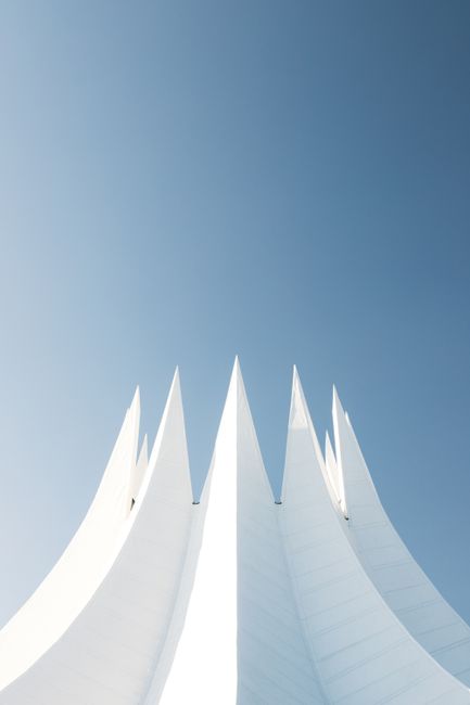 A striking minimalistic view of the Tempodrom in Berlin, showcasing its modern architecture under a clear blue sky.