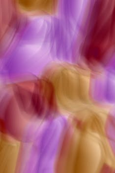 Colorful abstract image featuring motion blur in purple and gold hues, creating a dynamic, artistic design.