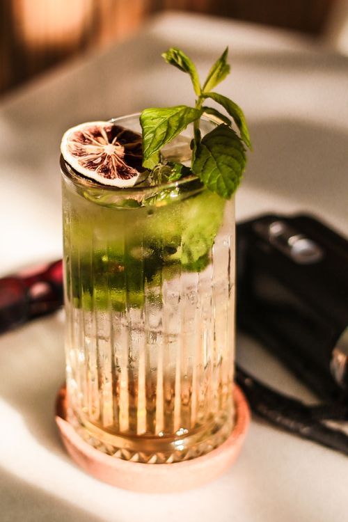 Free A tall glass of mojito garnished with mint leaves and a lime slice, perfect summer refreshment. Stock Photo