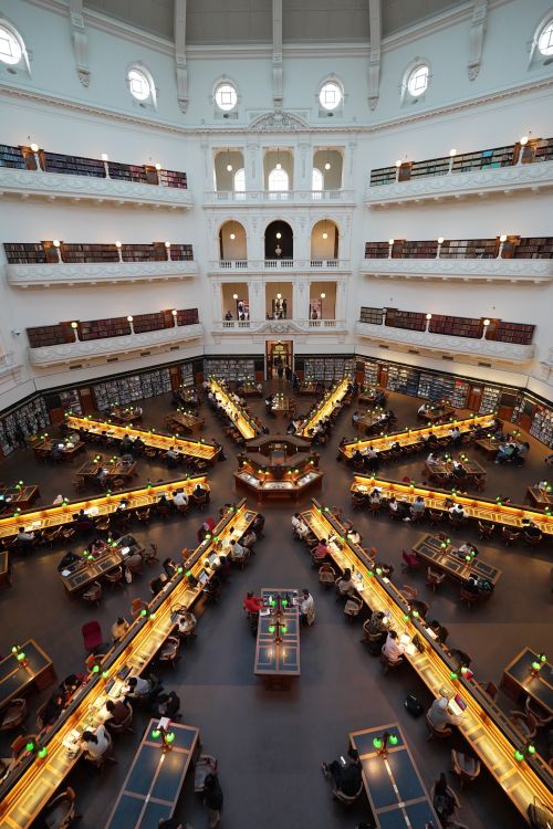 Free Stunning aerial view of Melbourne library's grand interior with symmetrical layout and reading desks. Stock Photo