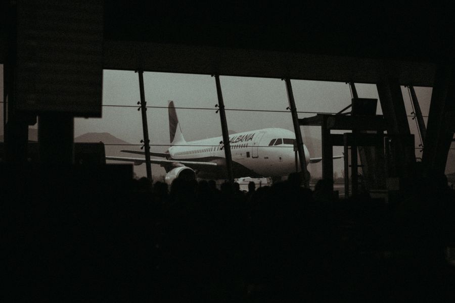 Silhouette of an airplane and waiting passengers inside an airport terminal