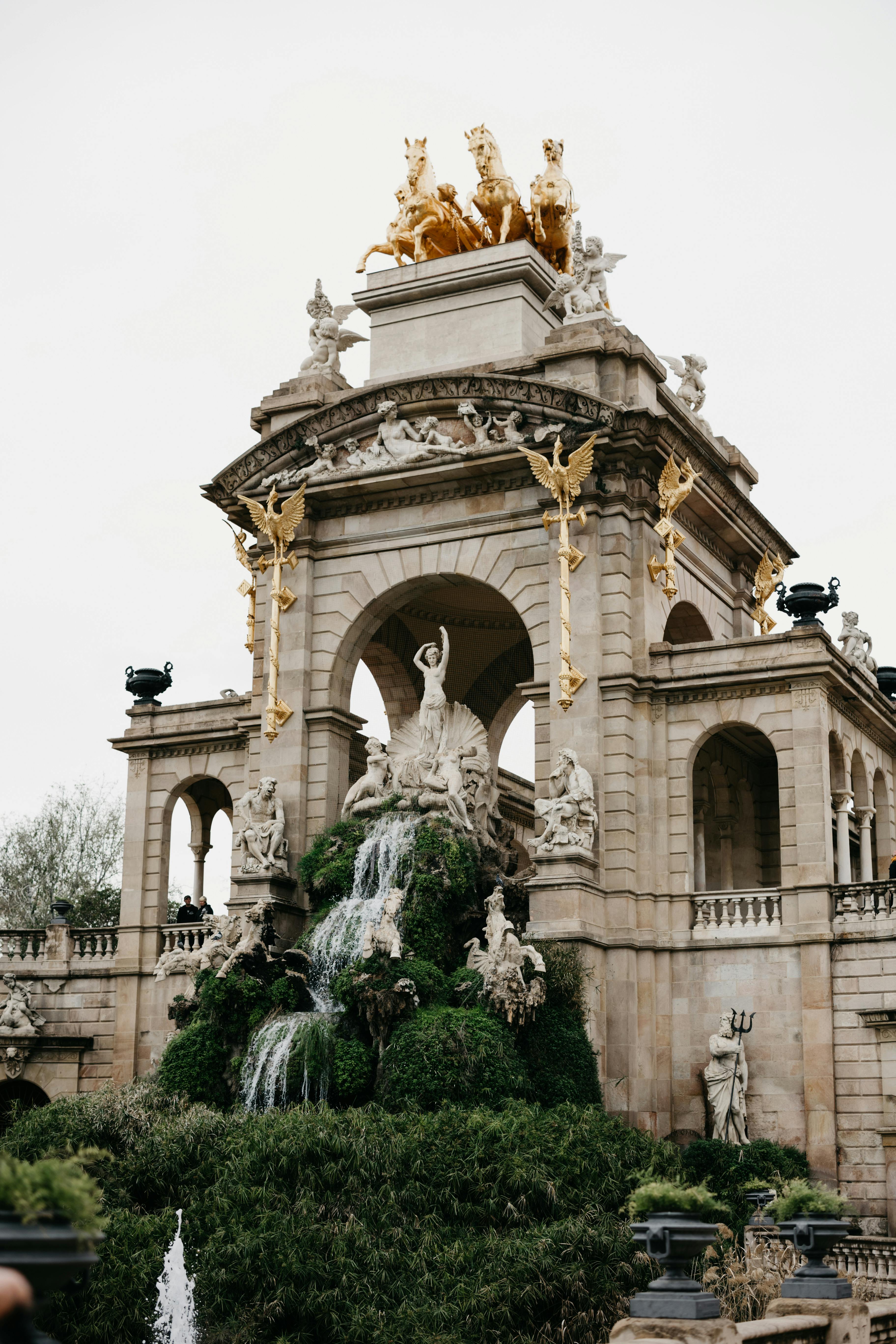 a fountain with a statue and a fountain in the background