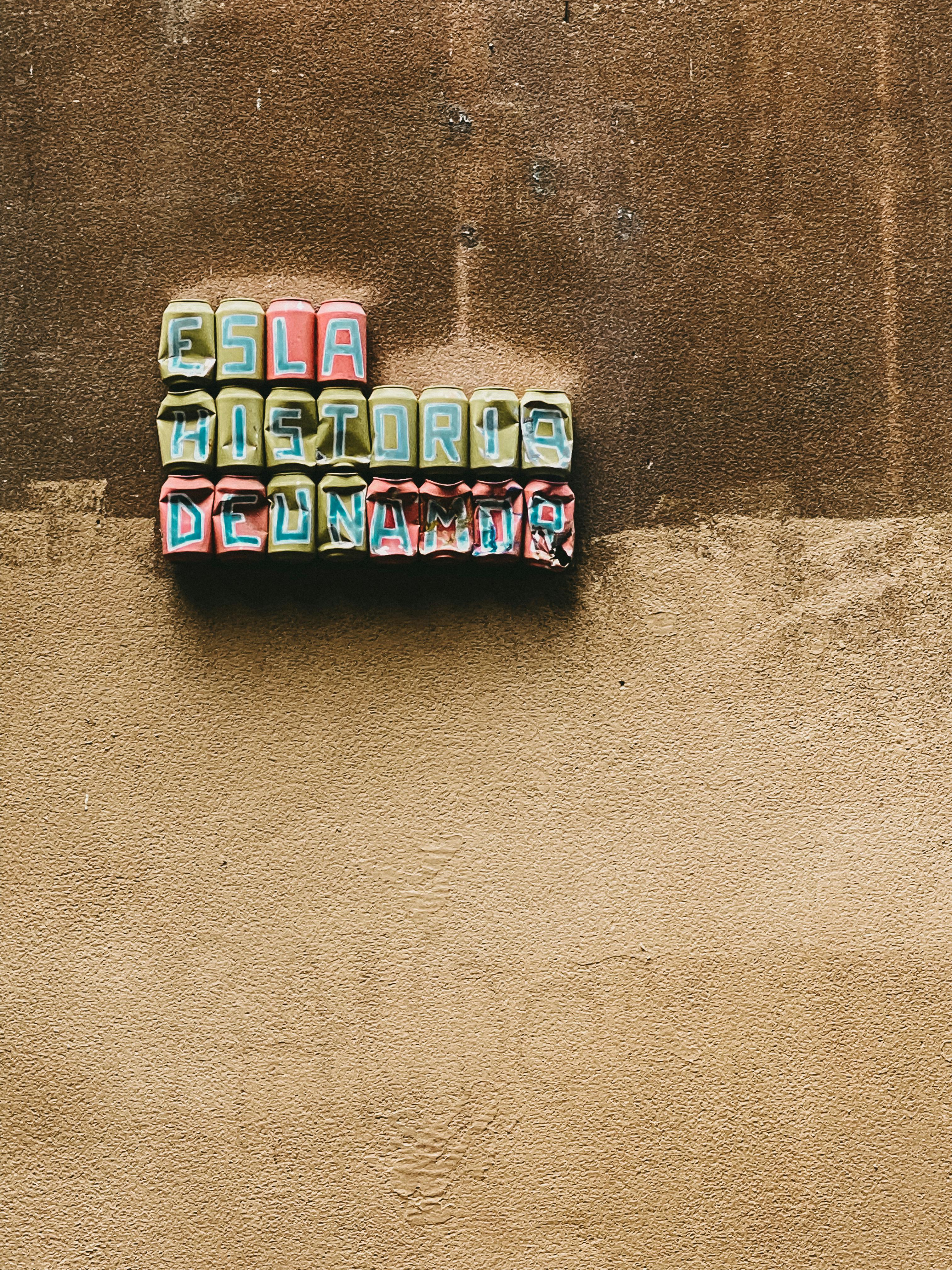 Colorful retro text art on a textured vintage wall, conveying nostalgia.