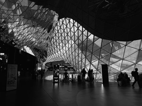 Black and white photo of people walking through an airport