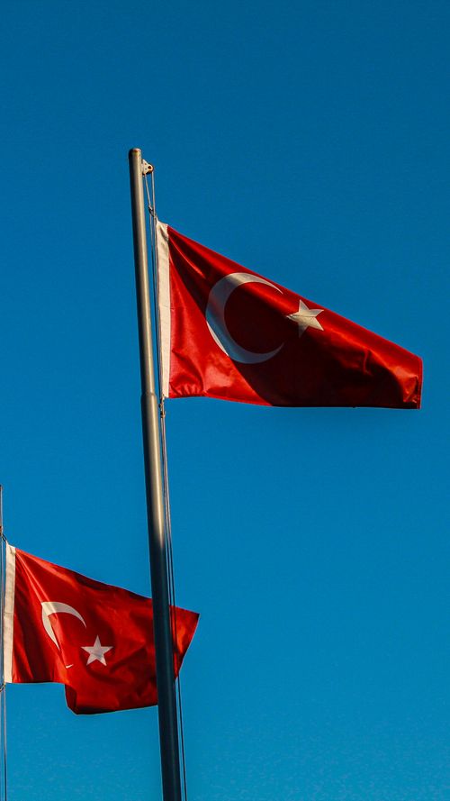 Free Turkish flags waving against a clear blue sky in Amasya, Türkiye, symbolizing national pride. Stock Photo