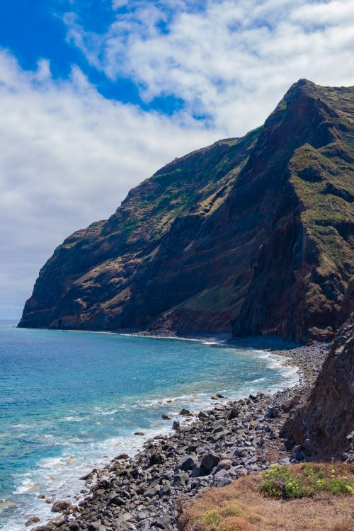 Free Stunning cliffs in Madeira, Portugal, with a breathtaking view of the turquoise ocean under a clear summer sky. Stock Photo