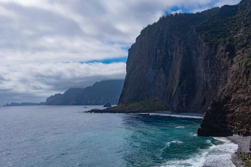 Free Explore the dramatic cliffs and serene blue waters of Madeira Island's seashore in Portugal. Stock Photo