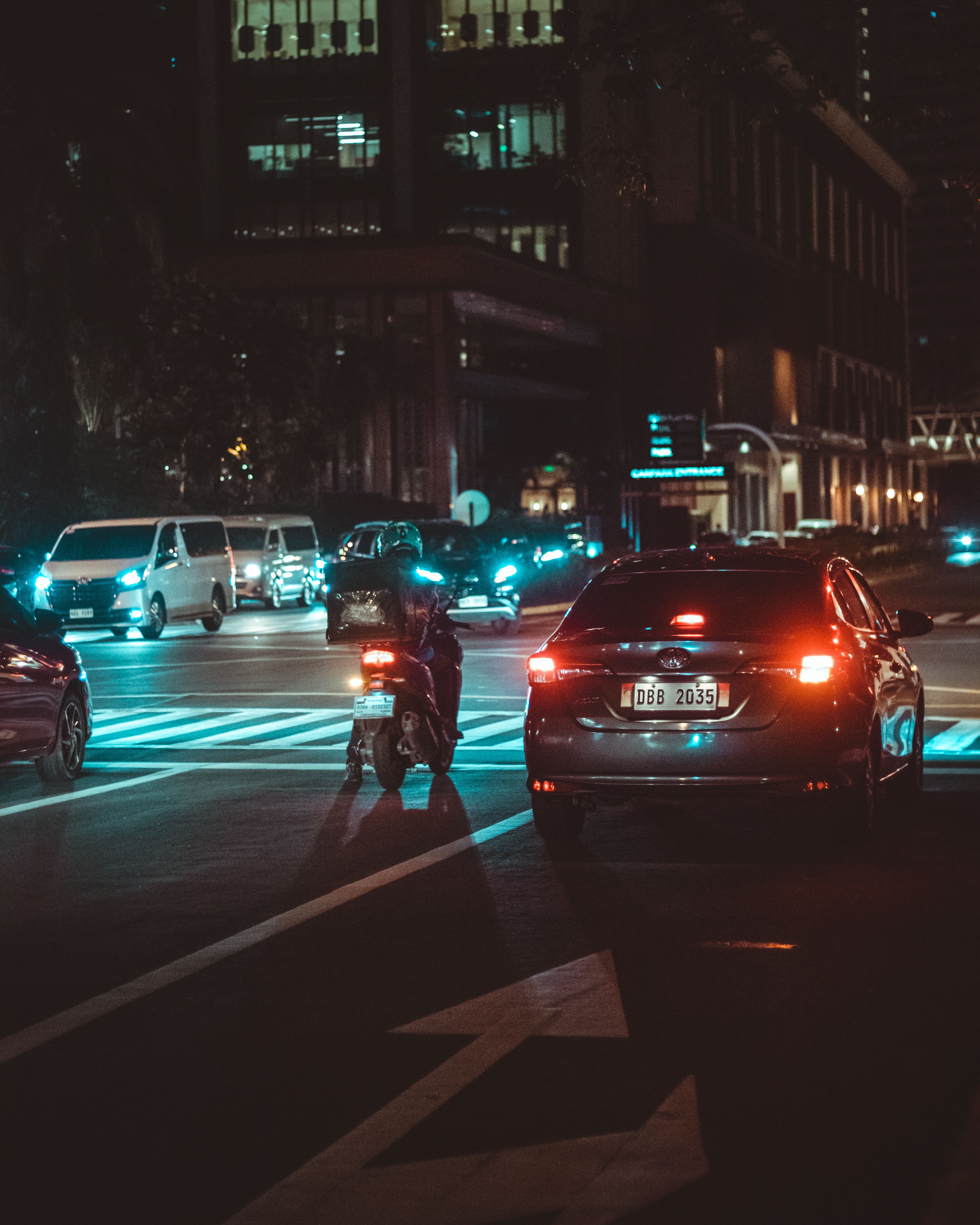 A car is driving down a street at night · Free Stock Photo