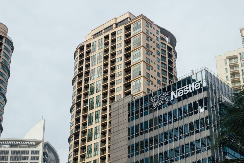 Urban skyline featuring high-rise offices and prominent building logos.