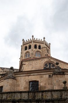 Close-up of a gothic stone tower showcasing historic architectural features under a cloudy sky.