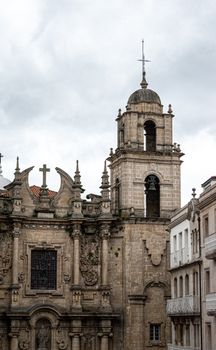 Historic gothic cathedral with intricate facade and bell tower on a cloudy day.