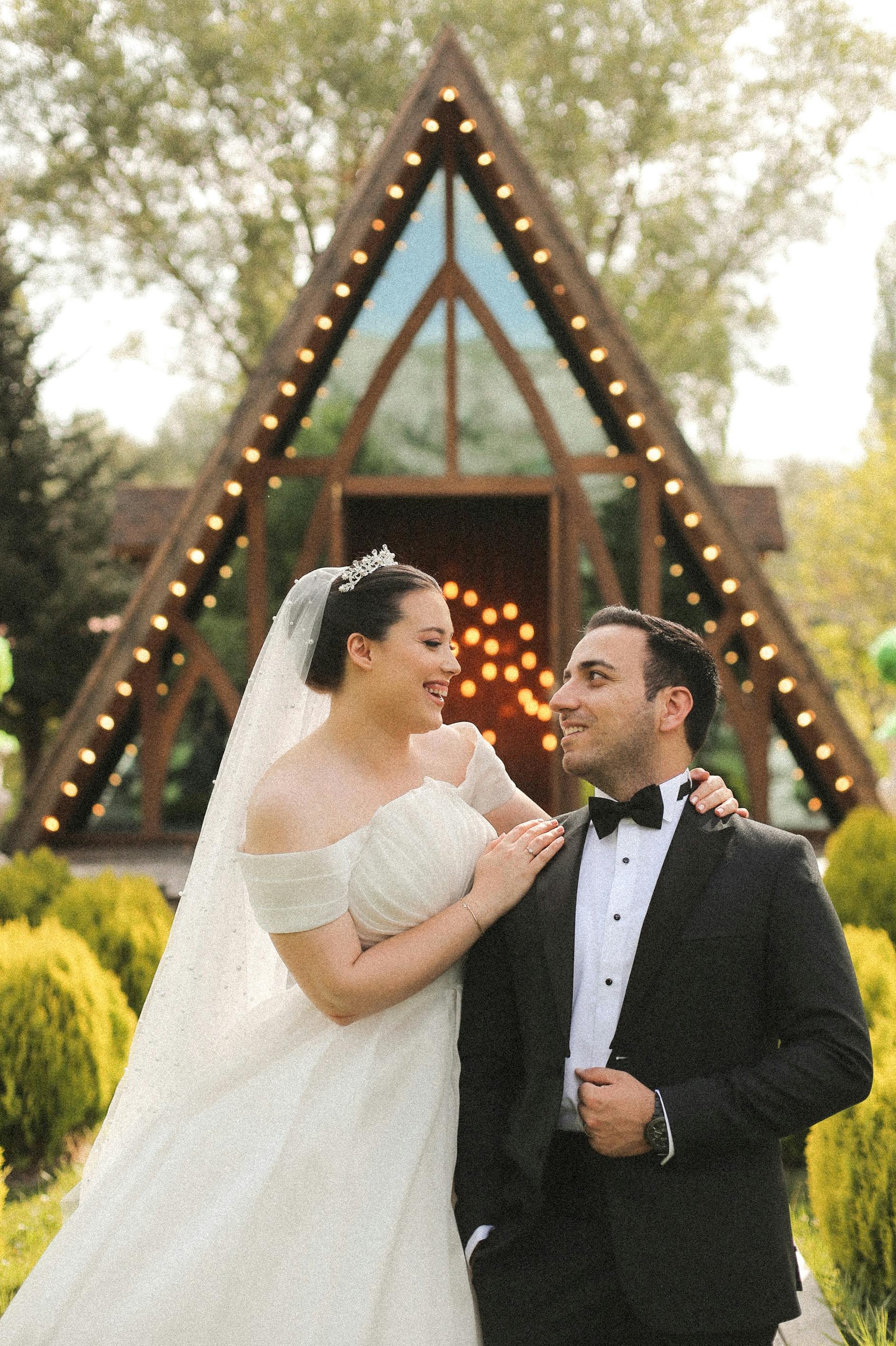 Bride and groom sharing a joyful moment at an outdoor wedding ceremony.