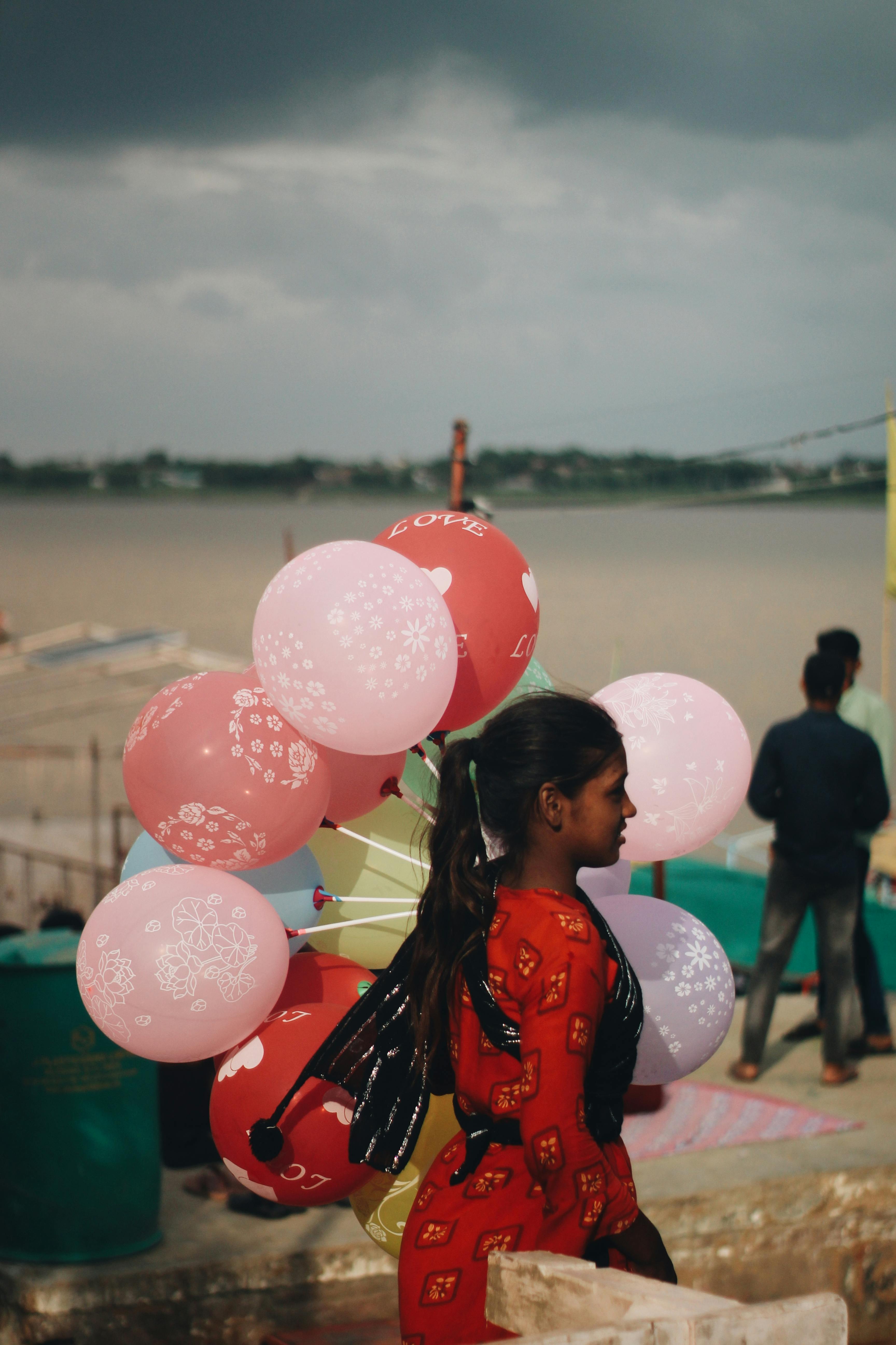A woman carrying balloons on the river