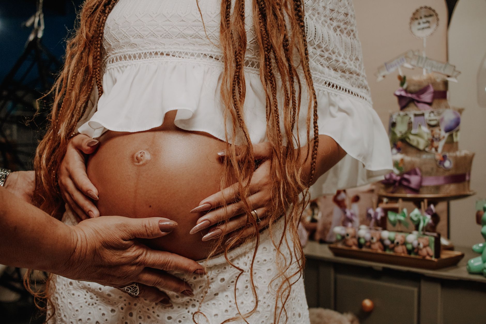 Pregnant woman lovingly embraced, celebrating motherhood with family indoors.
