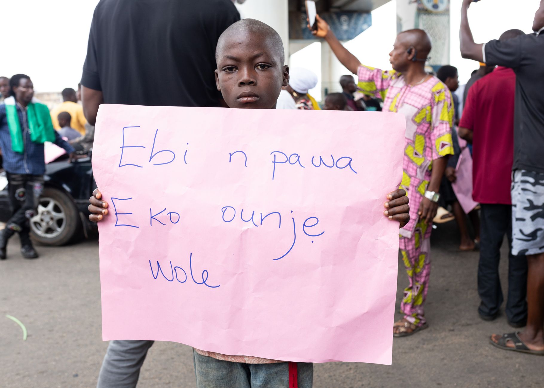A young boy participates in a street protest in Oshun, Nigeria, highlighting local issues.