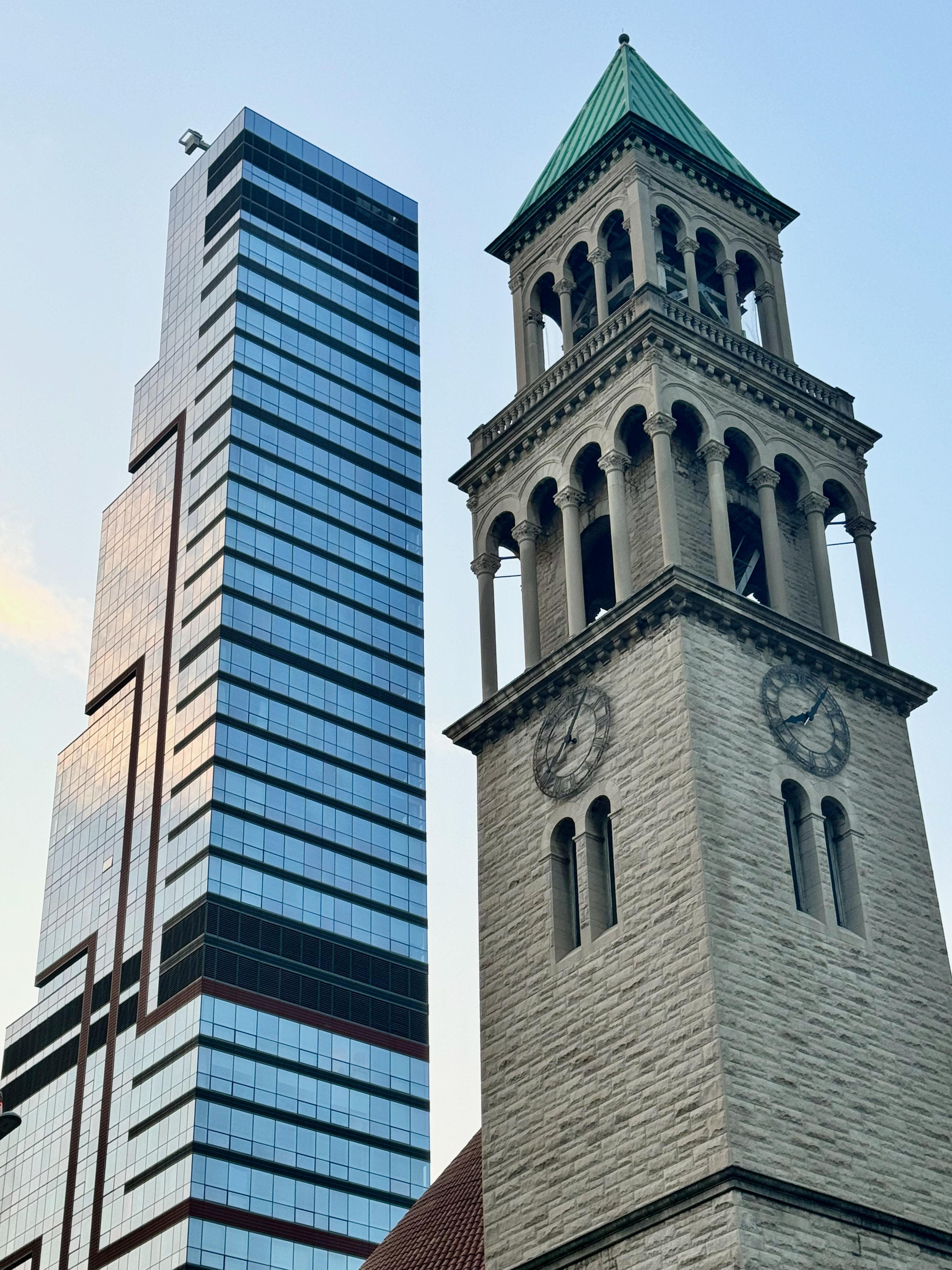 A tall tower with a clock on top and a church · Free Stock Photo