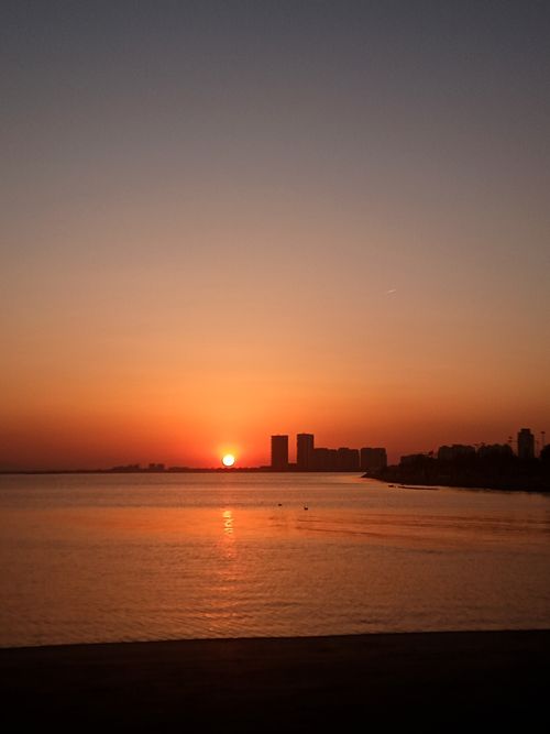 Free Dramatic sunset over İzmir's coastline with skyline silhouette and warm hues. Stock Photo