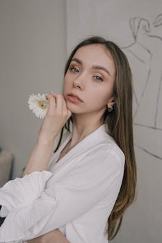Portrait of a stylish woman holding a white flower, showcasing elegance and beauty.