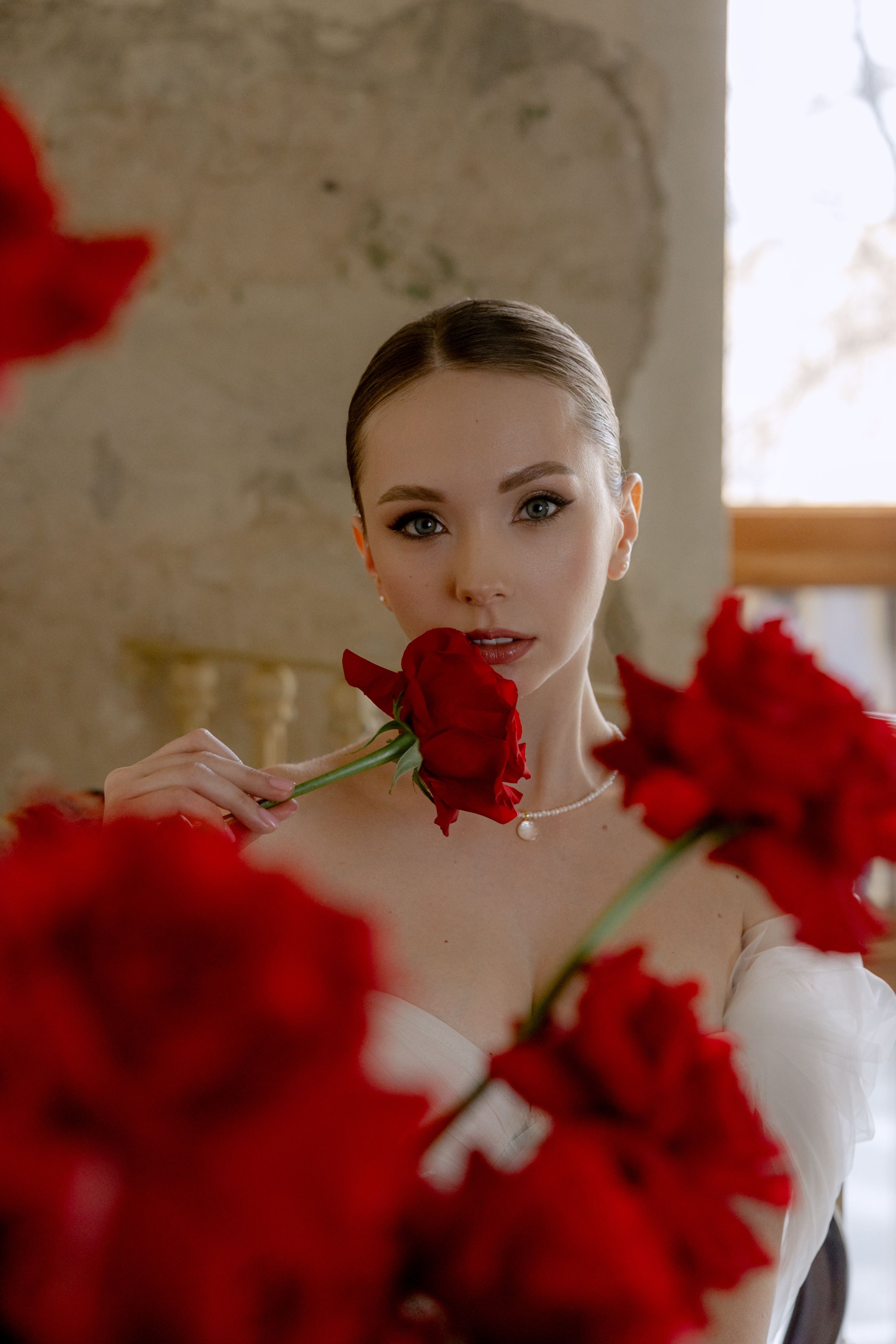 elegant-woman-holding-red-roses-indoors-free-stock-photo