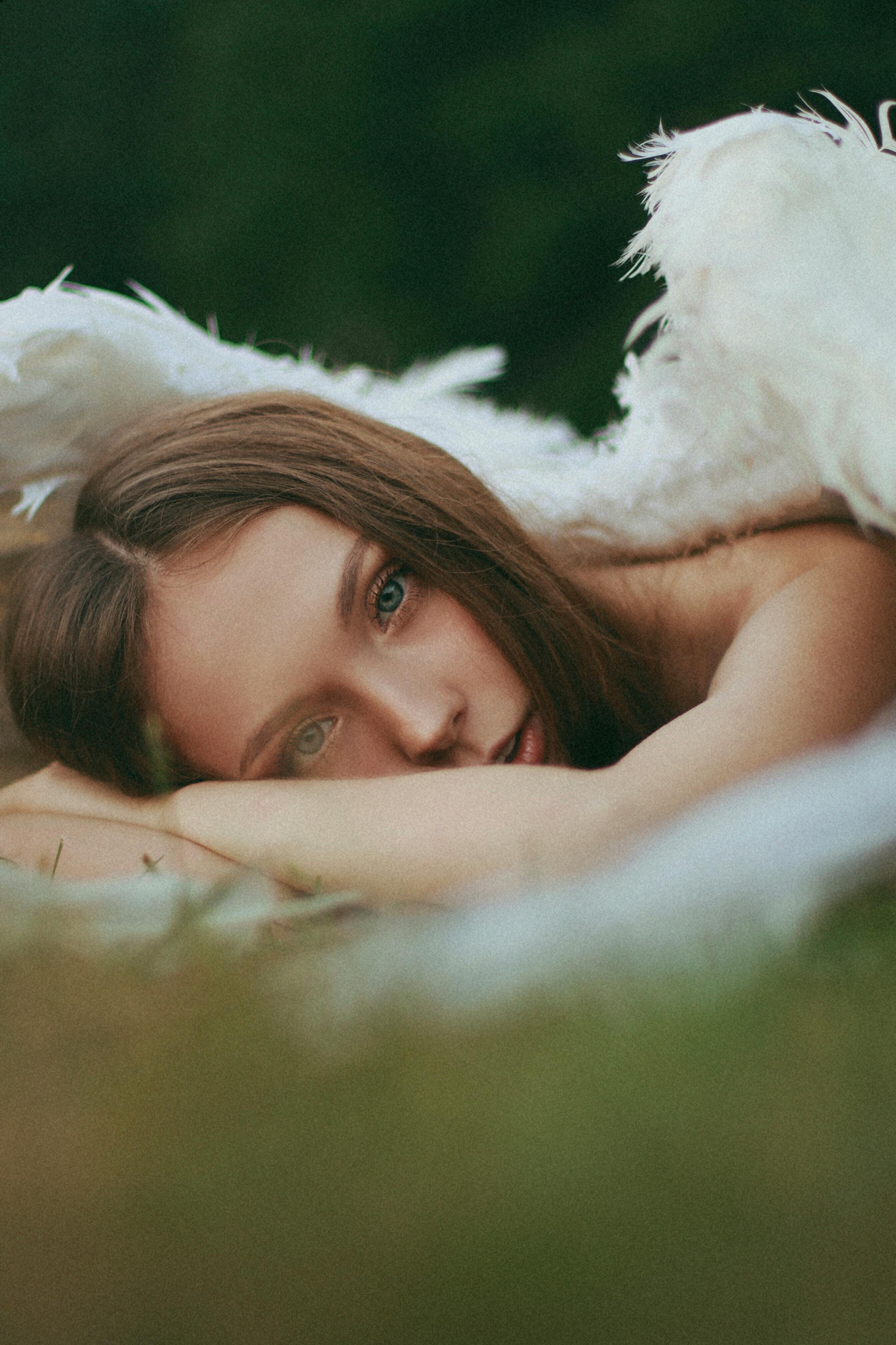 A serene woman reclines on a blanket outdoors, evoking relaxation.